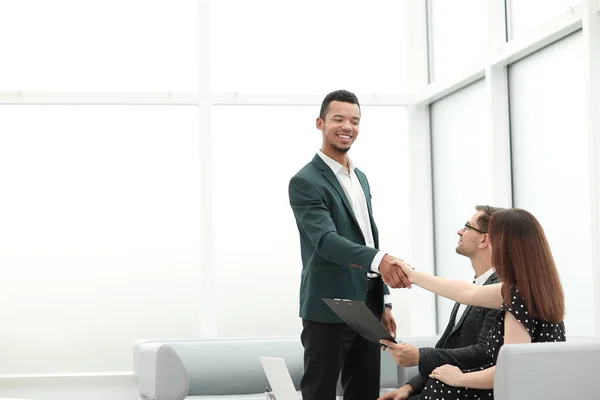 Lachende Manager begroet klanten in de lobby van het Bureau — Stockfoto