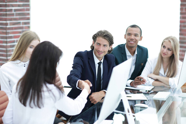 рукопожатие деловых женщин с деловым партнером за столом переговоров
