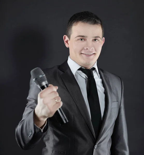 Joven empresario exitoso con microphone.isolated en negro — Foto de Stock