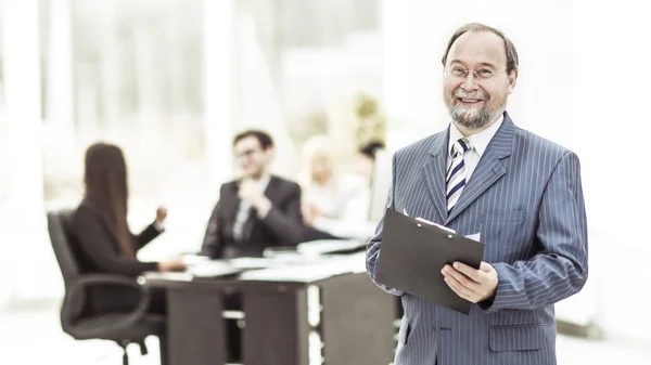 Framgångsrik affärsman med dokument på bakgrunden av det moderna kontoret — Stockfoto