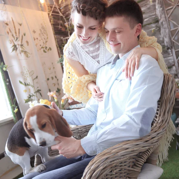 Jeune couple avec animal de compagnie assis sur une chaise — Photo