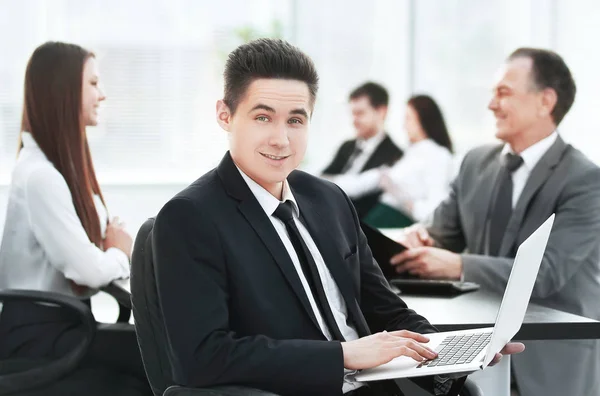 Porträtt av stilig ung affärsman och laptop — Stockfoto