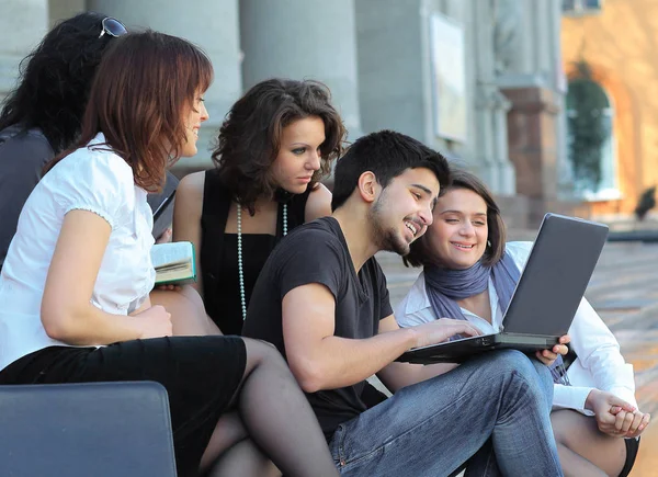 Group of fellow students with books and laptop — Stock Photo, Image