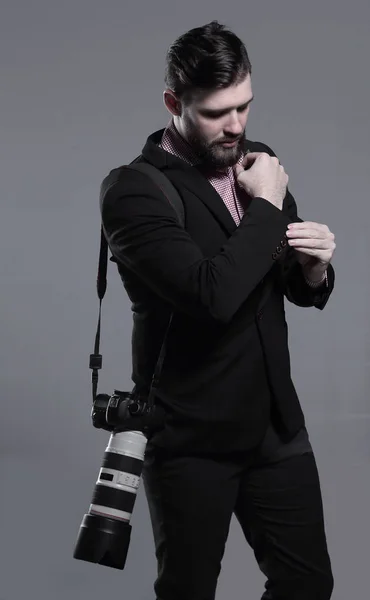 Fotógrafo profissional com câmera, ajustando um cufflink.isolated em fundo cinza — Fotografia de Stock