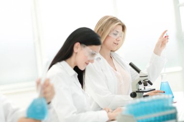 Genç bilim adamları laboratuvarda sıvıyı test ediyorlar.