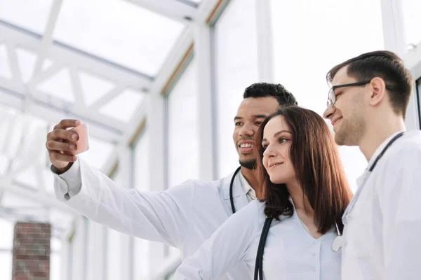 Groep van artsen stagiaires nemen van selfies in de lobby van het ziekenhuis — Stockfoto