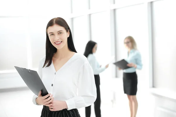Executive business woman with clipboard standing in office