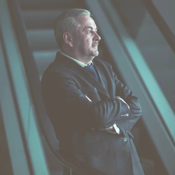 暗い背景に近代的なオフィスの階段の上に立って成功している実業家 — ストック写真