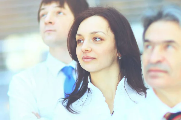 Successful business group in a row smiling and looking up — Stock Photo, Image