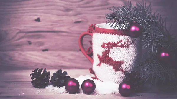 Рождественская кружка с вязаным украшением оленя на деревянном фоне — стоковое фото