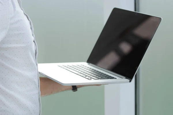 close up. businessman with laptop standing in the office.