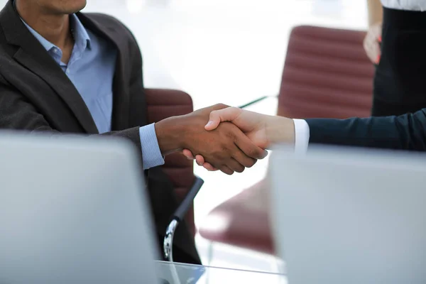 Closeup.handshake af samarbejdspartnere på baggrund af kontoret - Stock-foto