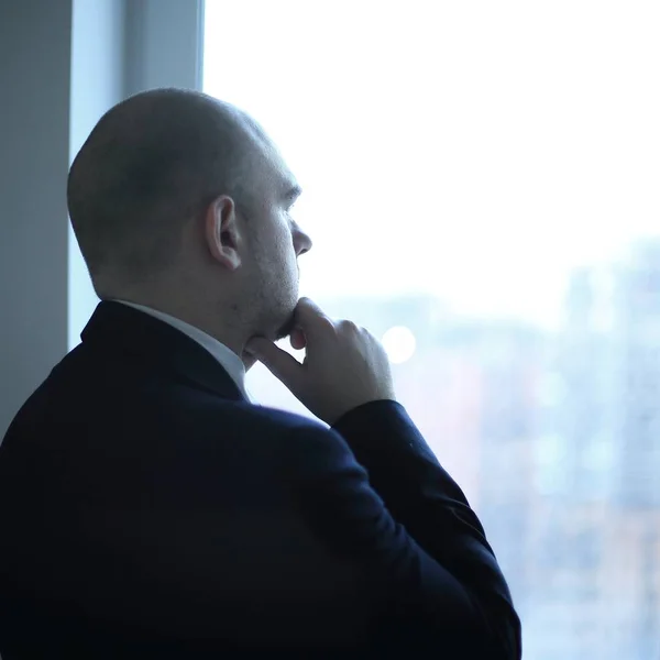 Fecha. homem de negócios pensativo olhando na janela do escritório — Fotografia de Stock