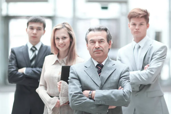 Hombre de negocios y su equipo de negocios en el fondo borrosa oficina —  Fotos de Stock