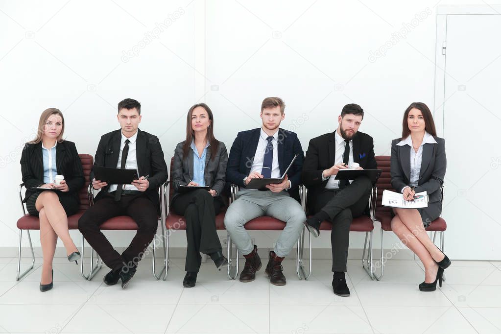 business team with clipboards sitting in a row