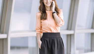 modern iş kadın smartphone cep telefonu ile modern bir ofis lobisinde dururken söz