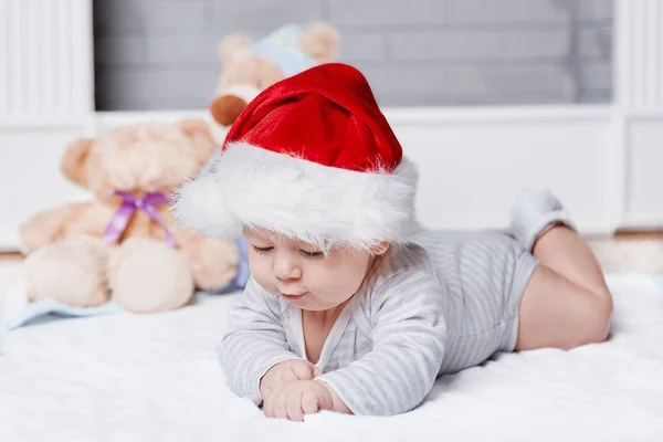 Happy baby in Santas hat on Christmas eve. — Stock Photo, Image