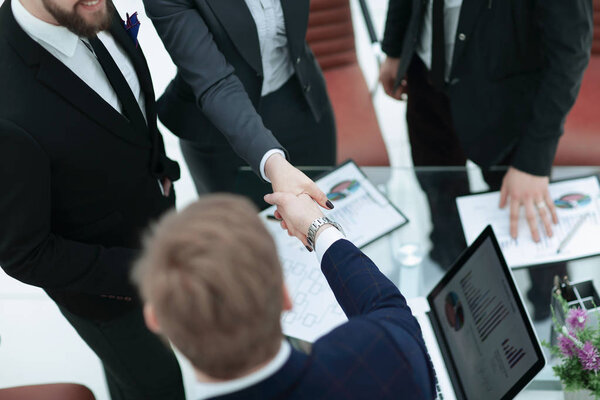 Закрывай. рукопожатие торговых партнеров за столом переговоров
