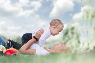 Anne ve küçük oğlu birlikte, çim üzerinde yalan oynamak .