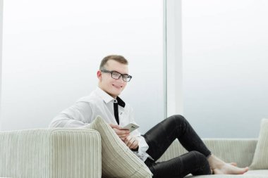 onun oturma odasında kanepede oturan iş adamı