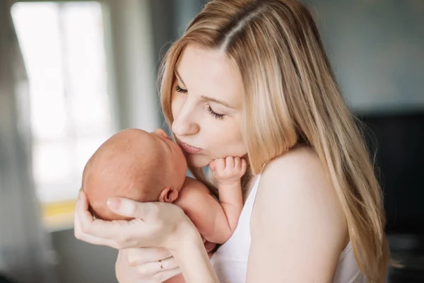 Szczęśliwa mama z noworodka stoi w pokoju. — Zdjęcie stockowe