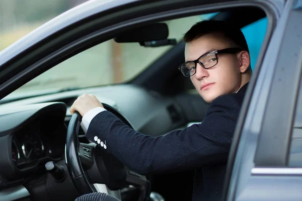 Zamknij up.successful siedząc za kierownicą samochodu młody biznesmen. — Zdjęcie stockowe