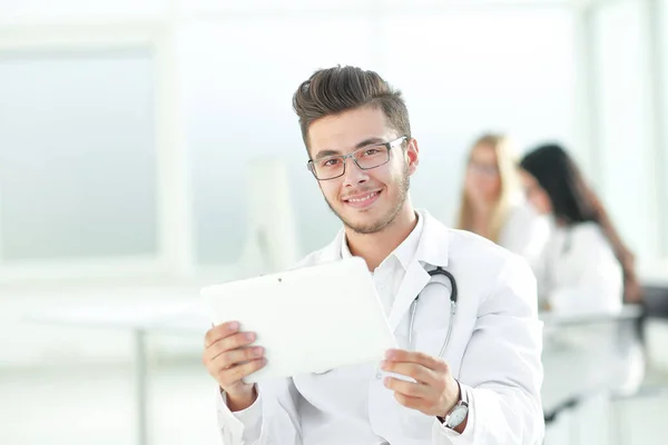 Médico sonriente mirando la pantalla digital de la tableta — Foto de Stock