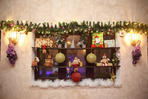 Mensola decorativa con decorazioni natalizie a parete in soggiorno — Foto Stock
