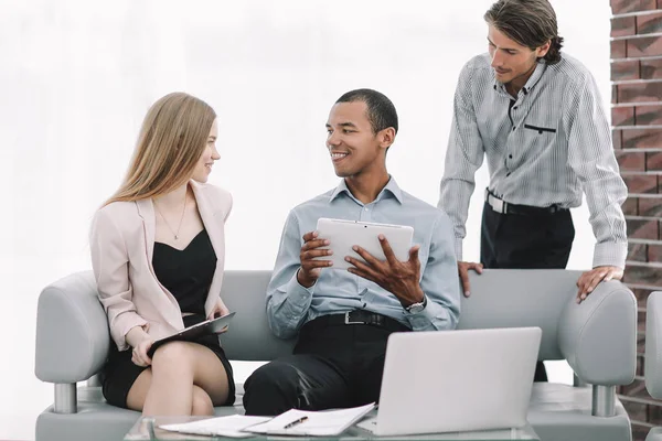 Equipo de negocios que utiliza la tableta digital en el vestíbulo de la oficina — Foto de Stock