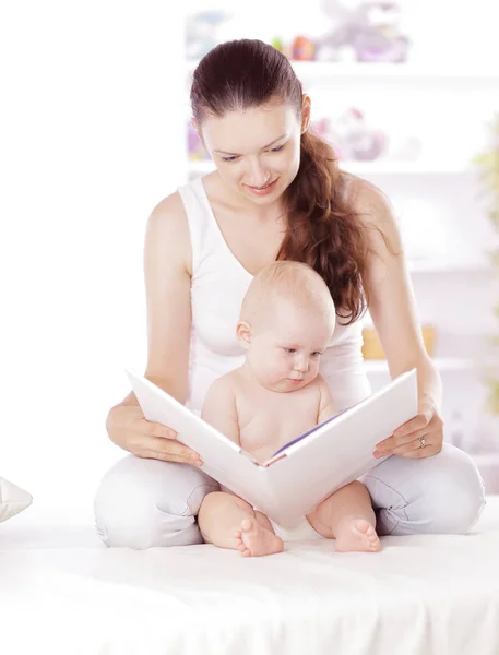 Encantadora mamá leyendo un libro a su bebé — Foto de Stock