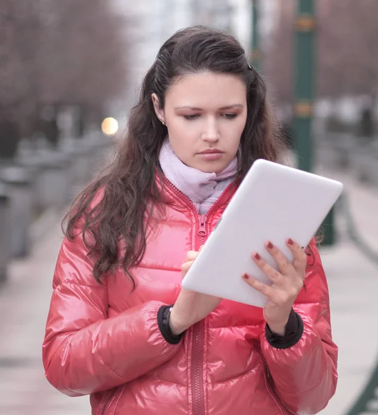 Jonge vrouw met digitale tablet op de achtergrond van de stad — Stockfoto