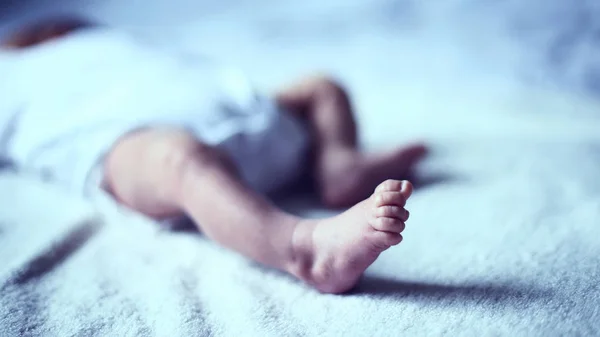 Noha novorozence, který se klidně spí v postýlce — Stock fotografie