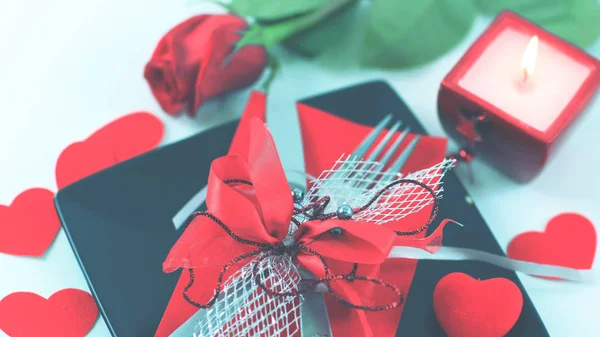 Cubiertos en plato oscuro con una vela decorada para el día de San Valentín —  Fotos de Stock