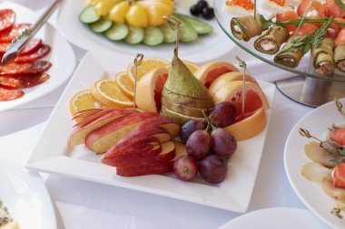 Üzüm, portakal ve masanın üzerine armut