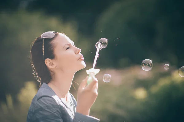 Close up. beautiful young woman blowing bubbles — Stock Photo, Image