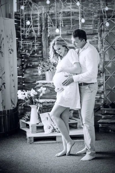 Foto en estilo retro. marido cariñoso mirando a sus esposas embarazadas vientre — Foto de Stock