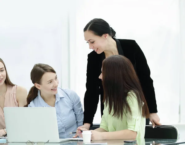 Lachende groep vrouwen achter een bureau in het kantoor — Stockfoto