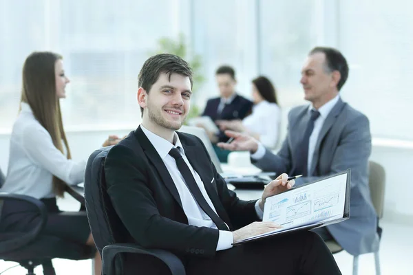 Hombre de negocios en la oficina con su equipo de negocios trabajando detrás —  Fotos de Stock