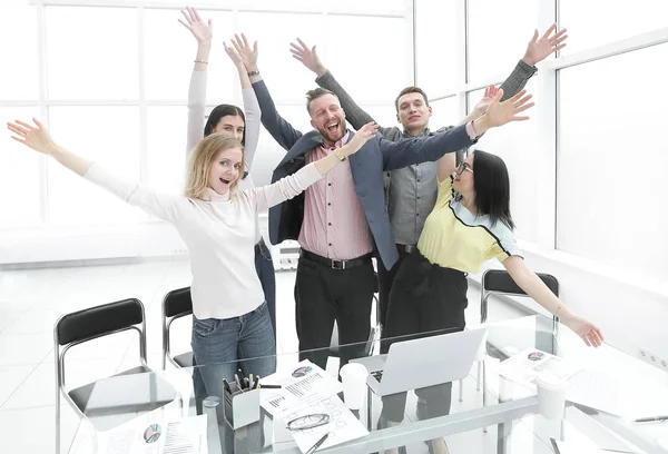 Feliz equipo de negocios de pie en la oficina y mostrando su éxito . —  Fotos de Stock