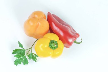 üç tatlı biber ve maydanoz üzerinde beyaz izole bir delikanlı