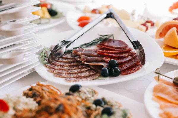Prato com produtos à base de carne em fatias na mesa festiva — Fotografia de Stock