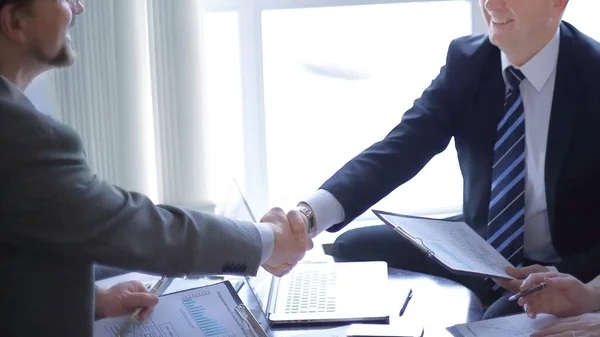 Handshake starších obchodních partnerů na stole — Stock fotografie