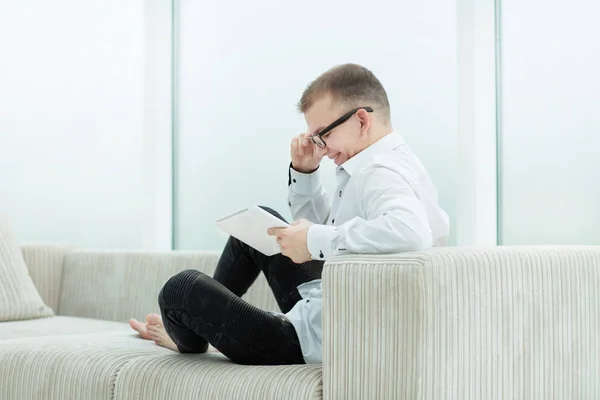 Glimlachende man op zoek door middel van mediabestanden op zijn Tablet PC — Stockfoto