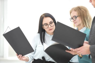 ofiste ayakta iş belgeleri tartışırken çalışanlar