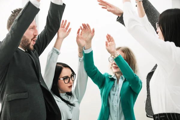 Close up. Business team di successo in piedi in ufficio e alzando le mani — Foto Stock