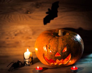 Mumlar, balkabakları ve tahta arka planda bir örümcek.