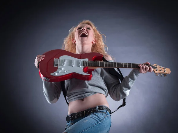 Menina atraente emocionalmente tocando a guitarra elétrica . — Fotografia de Stock