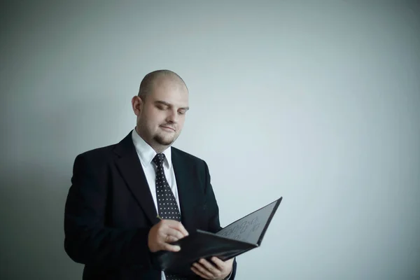 Empresário sério assina um documento .isolated em fundo cinza — Fotografia de Stock