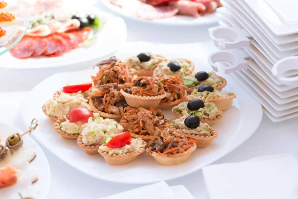 Slices of salmon, rolls of pancakes and mushrooms on a snack plate — Stock Photo, Image