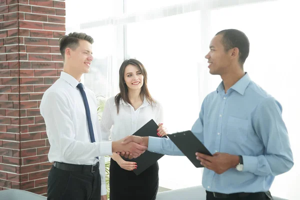 Handshake mladých obchodních partnerů v kanceláři — Stock fotografie